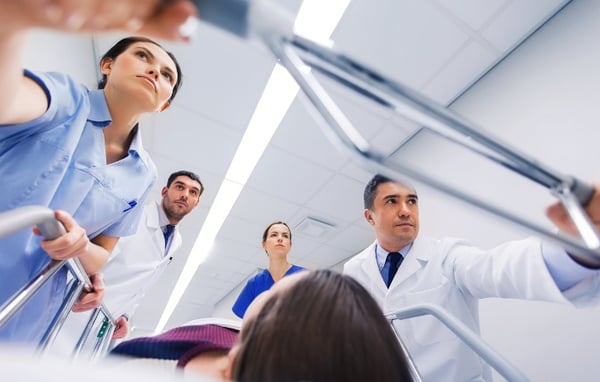 medics-with-woman-on-hospital-gurney-at-emergency-706x450