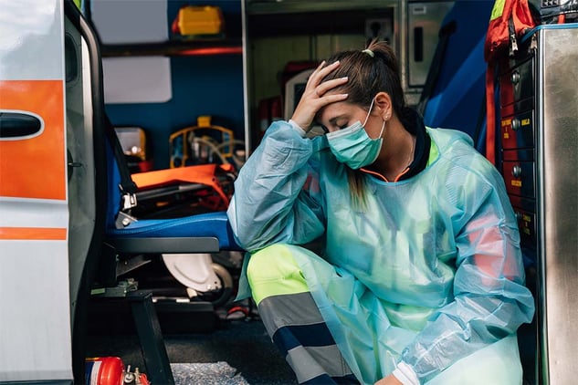 tired-medic-sitting-in-amb-ppe-1000x667