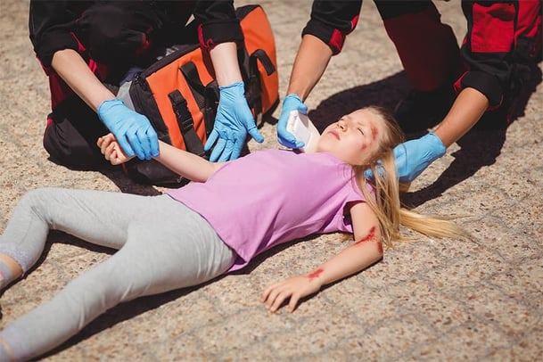 paramedics-examining-injured-girl-2-compressed-900x600