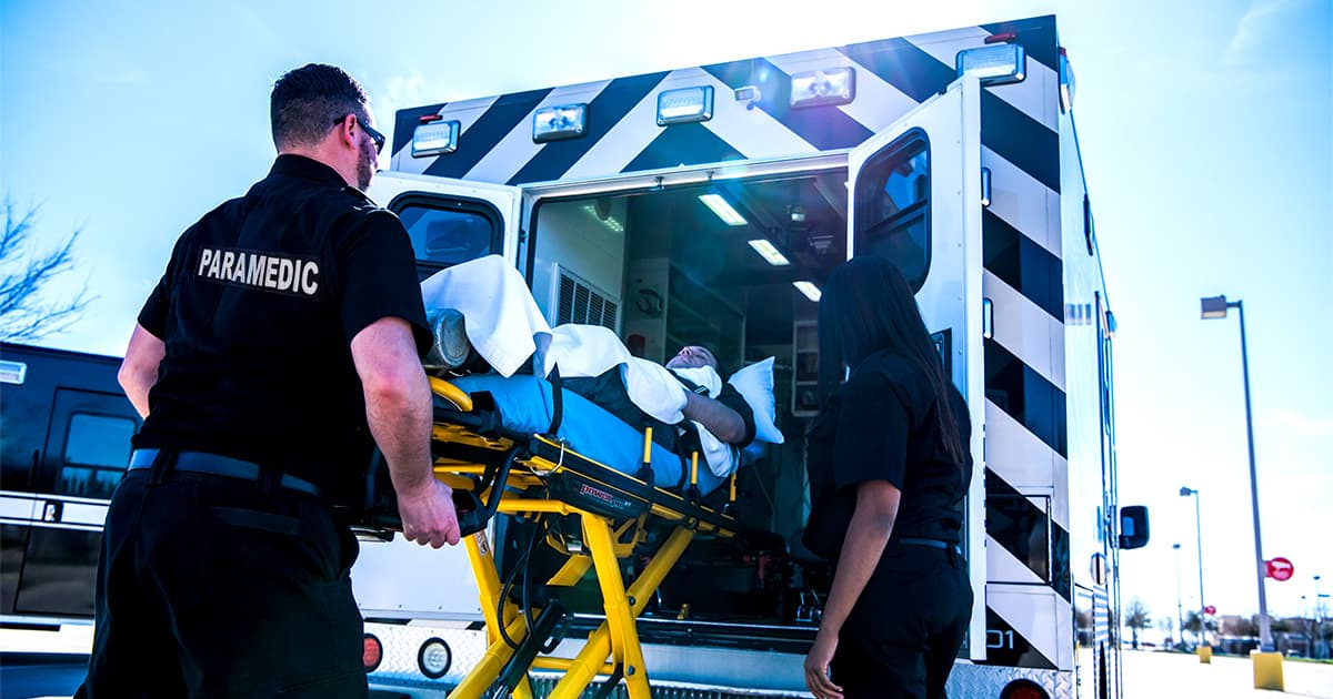Medics load a patient into an ambulance